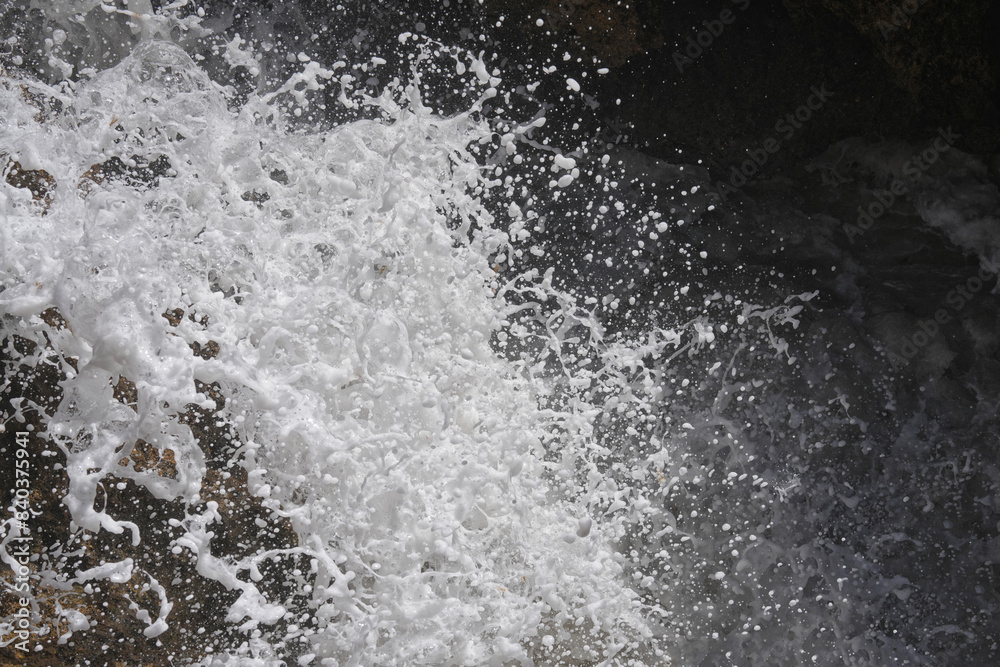 Wild aufschäumende Wellen zeigen ihr Spiel mit zahlreichen Wassertropfen Wild aufschäumende Wellen zeigen ihr Spiel mit zahlreichen Wassertropfen