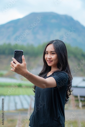 Woman taking a self in a mountainous outdoor setting