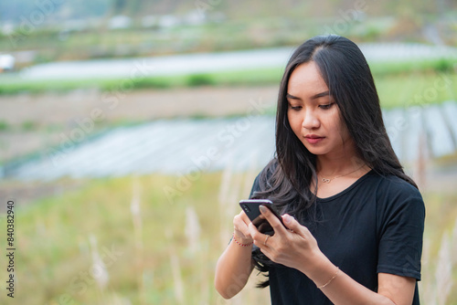 Slika na platnu Young woman using smart phone in rural area