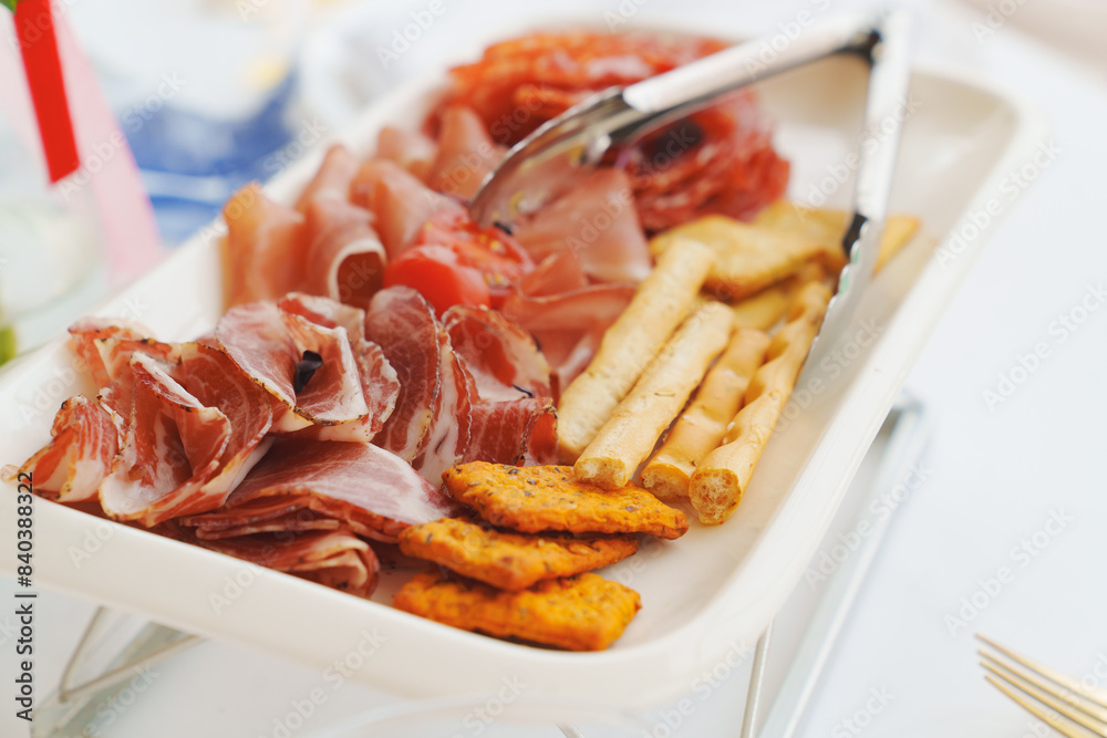 A plate with cold cuts and breadsticks. A delicious jerky appetizer. A plate with cold cuts and breadsticks. A delicious jerky appetizer.