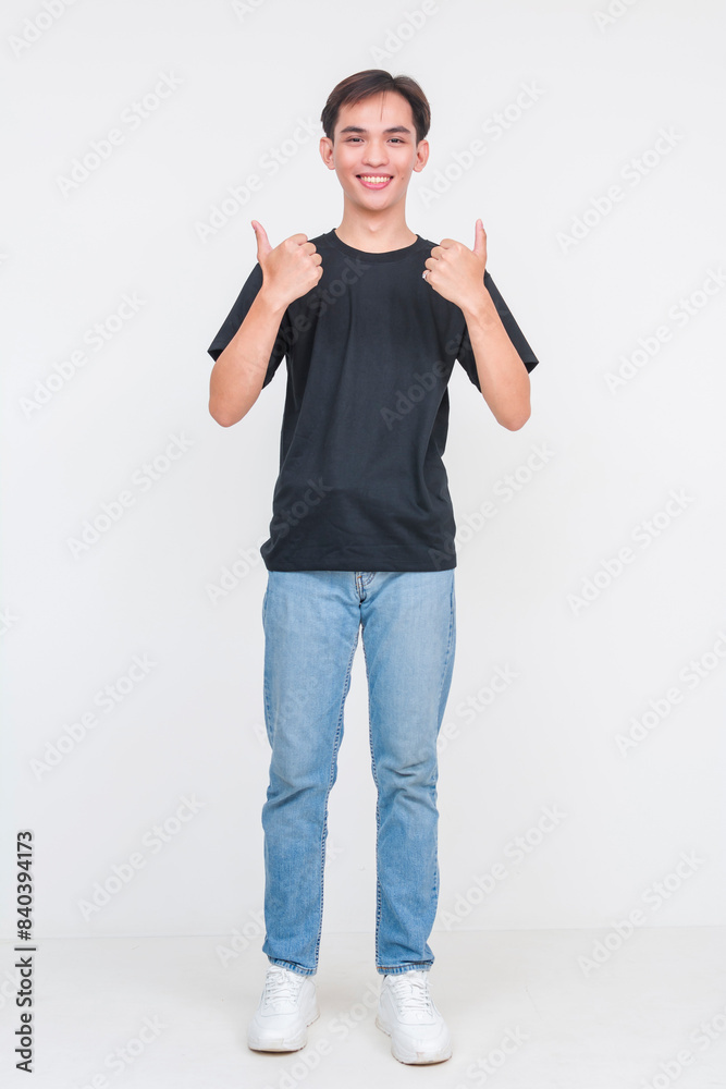 Young asian man in casual outfit giving thumbs up Young asian man in casual outfit giving thumbs up