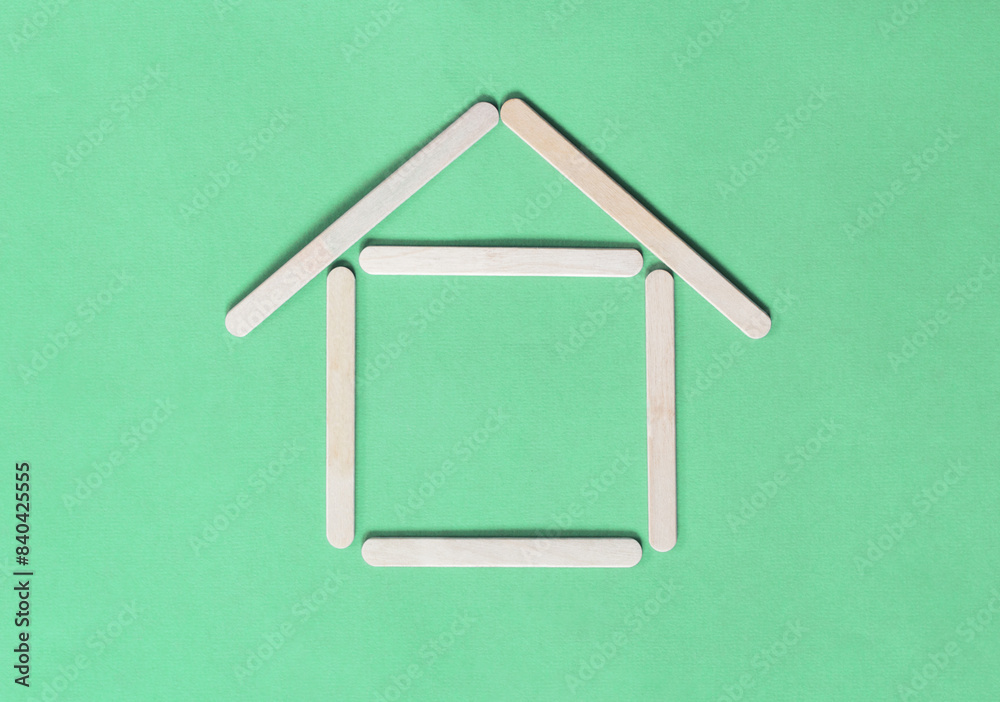 House made of wooden sticks on green background. Eco conceipt. House made of wooden sticks on green background. Eco conceipt.