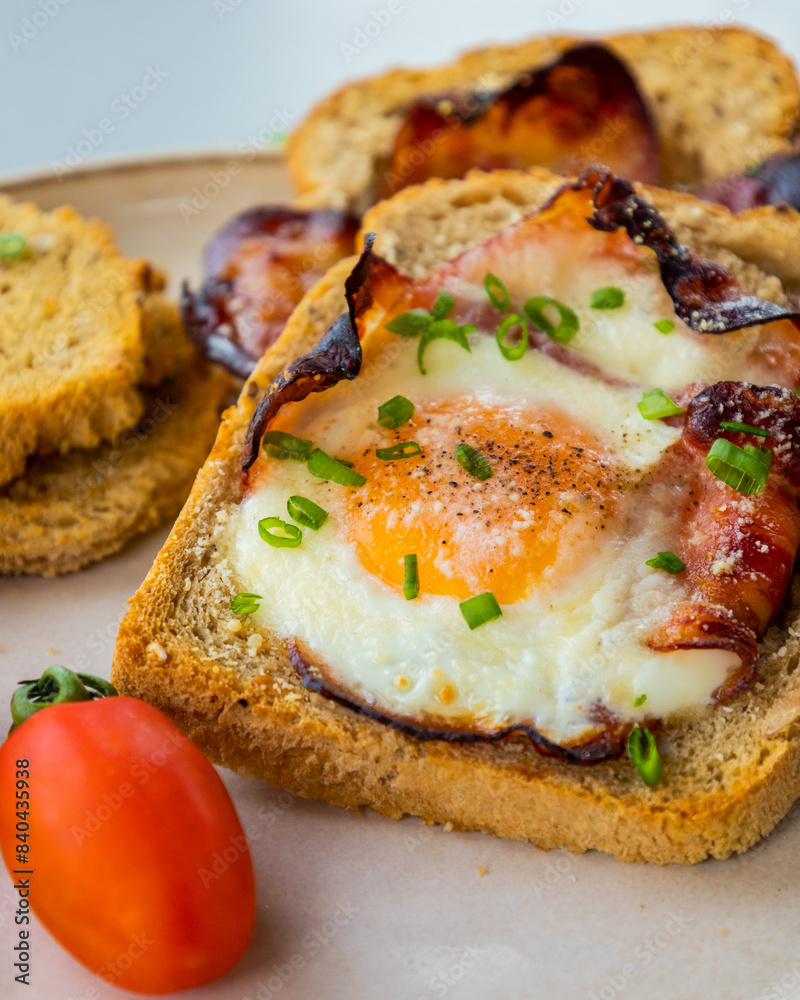 Baked Bacon and Eggs in Bread on White Plate with Fresh Green Onion Close-Up Baked Bacon and Eggs in Bread on White Plate with Fresh Green Onion Close-Up