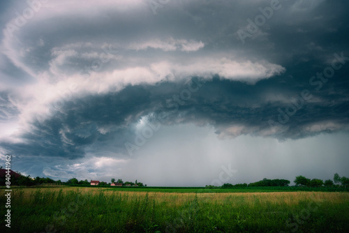 Beautiful and Amazing Ominous Supercell Thunderstorm Clouds over Green Fields in Summer