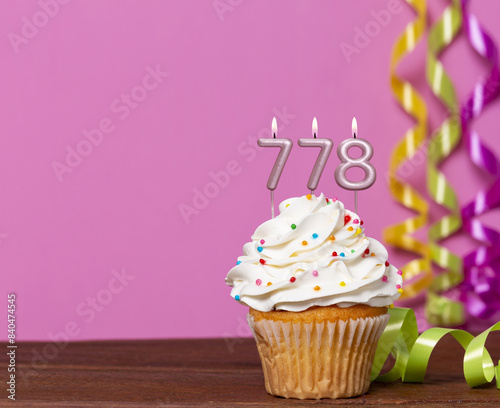 Birthday Cupcake With Candles Lit Forming The Number 778