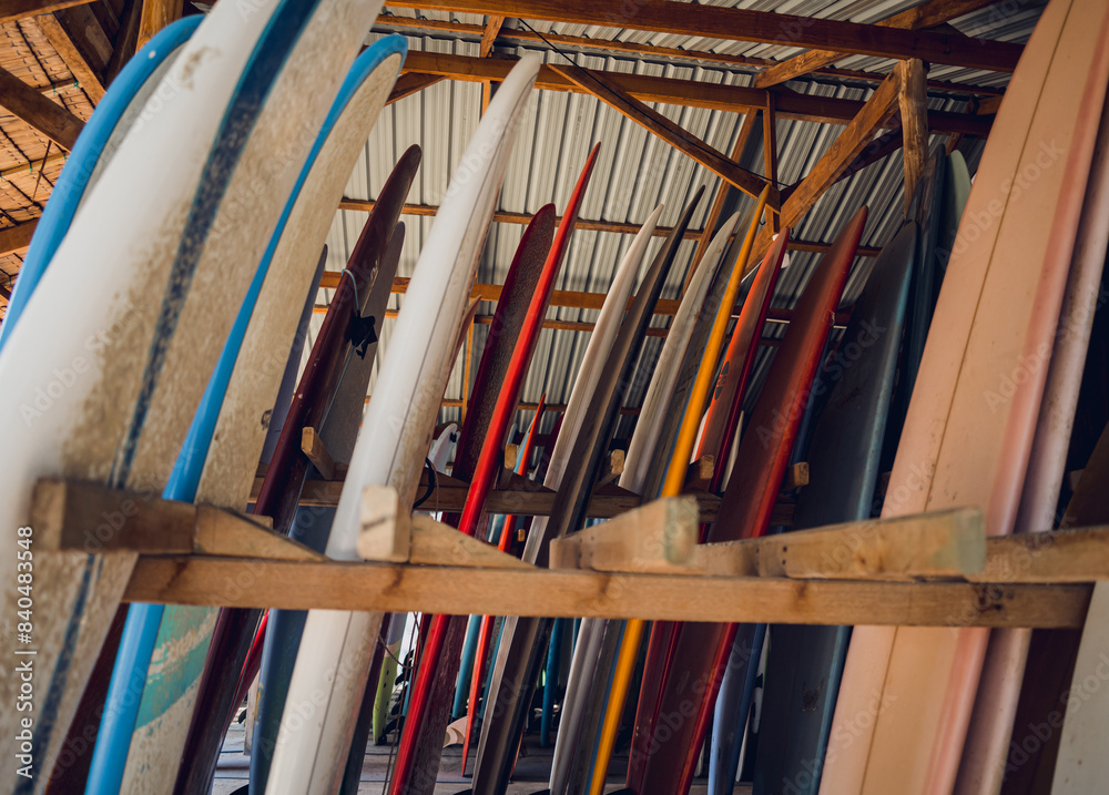 A variety of surfboards are neatly displayed on a stand A variety of surfboards are neatly displayed on a stand