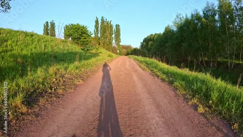 Riding a bicycle in the open air with a sunset backdrop, seen from the bike. A concept of scenic landscapes and cycling relaxation.