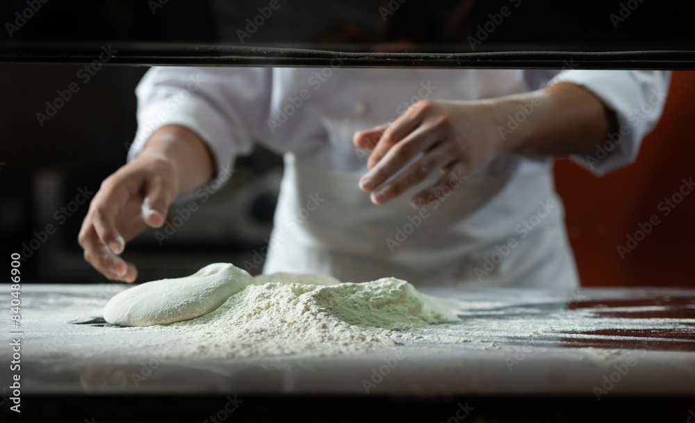 experienced chef - Professional chef prepares the dough with flour to make pizza or pasta Italian food experienced chef - Professional chef prepares the dough with flour to make pizza or pasta Italian food