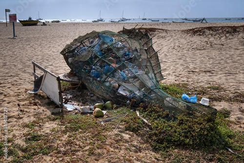 Net in the shape of a Fish full of Plastic Containers and Plastic Waste with extra plastic spilling out, Praia de Santa Maria Beach, Santa Maria, Sal, Cape Verde Islands, Atlantic photo