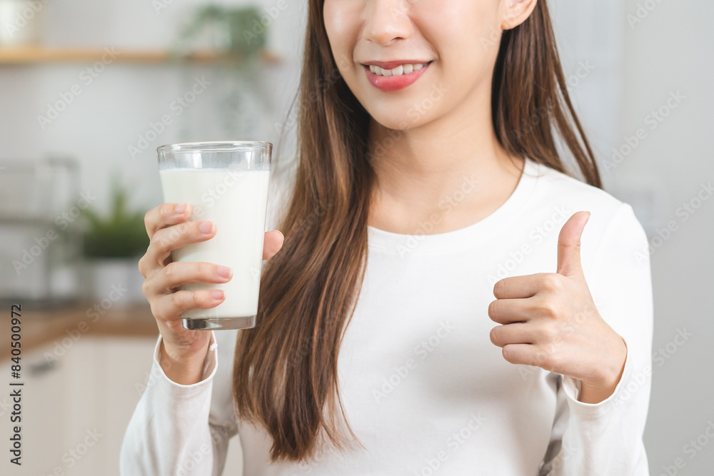 Health care, smile asian young woman, girl showing thumb up, holding glass of fresh, dairy soy milk to drink for calcium, vitamin wholesome good nutrition in morning at home, product of healthy people Health care, smile asian young woman, girl showing thumb up, holding glass of fresh, dairy soy milk to drink for calcium, vitamin wholesome good nutrition in morning at home, product of healthy people