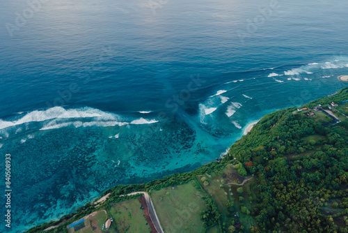 Drone view of coastline with ocean waves and current canal in Bali. Green bowl beach