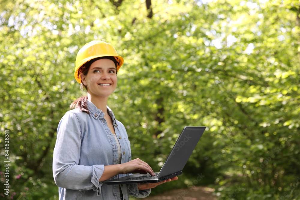 Forester with laptop examining plants in forest, space for text Forester with laptop examining plants in forest, space for text