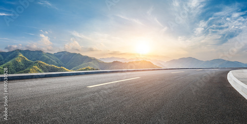 Asphalt highway road and green mountain with sky clouds at sunset