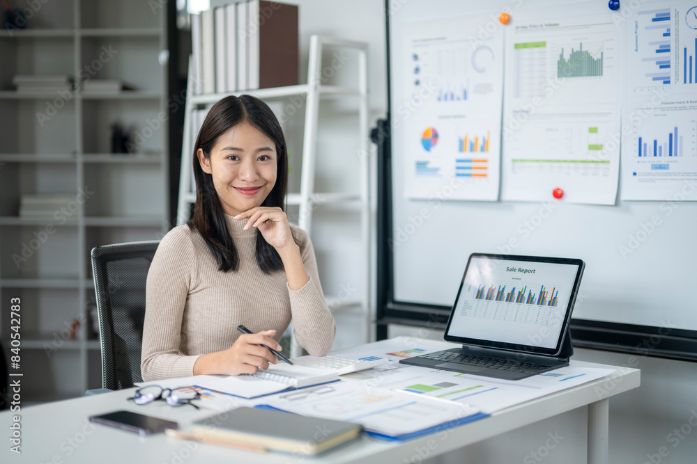 A woman is sitting at a desk with a laptop and a notebook A woman is sitting at a desk with a laptop and a notebook
