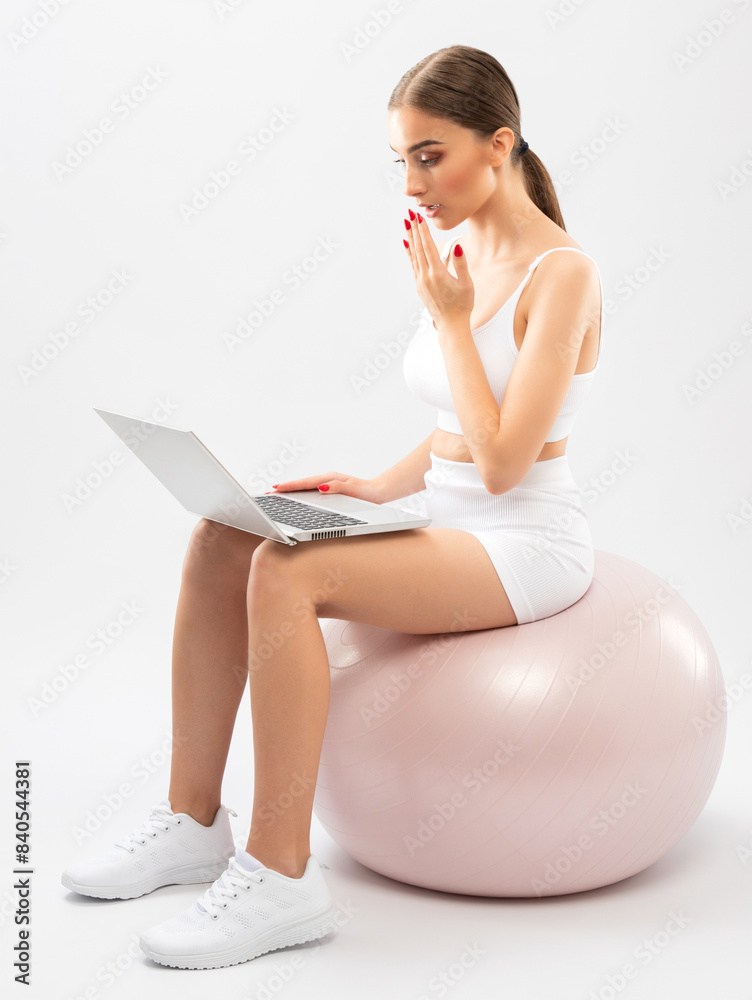 Naklejka premium Slender dark-skinned female blogger in a white tracksuit against a white background. Healthy lifestyle, sports and diet.