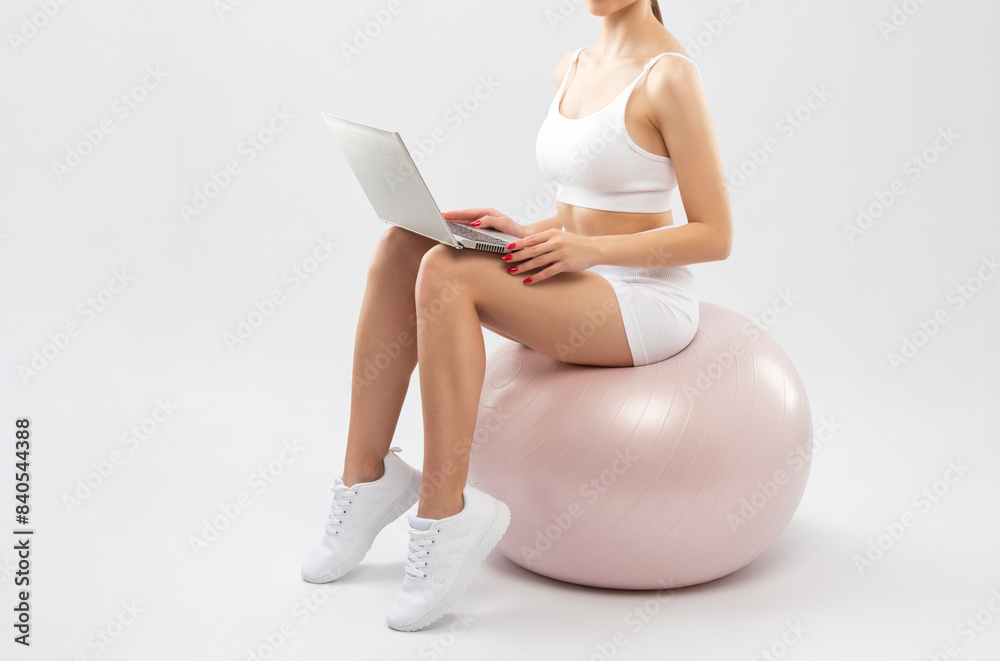 Naklejka premium Slender dark-skinned female blogger in a white tracksuit against a white background. Healthy lifestyle, sports and diet.