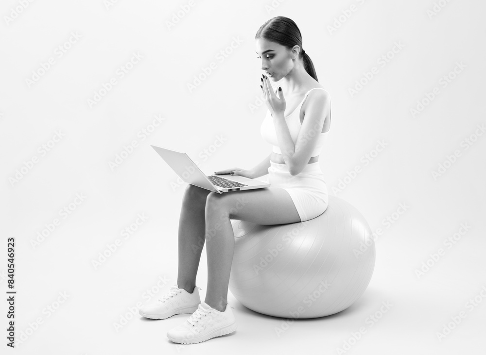 Naklejka premium Slender dark-skinned female blogger in a white tracksuit against a white background. Healthy lifestyle, sports and diet.