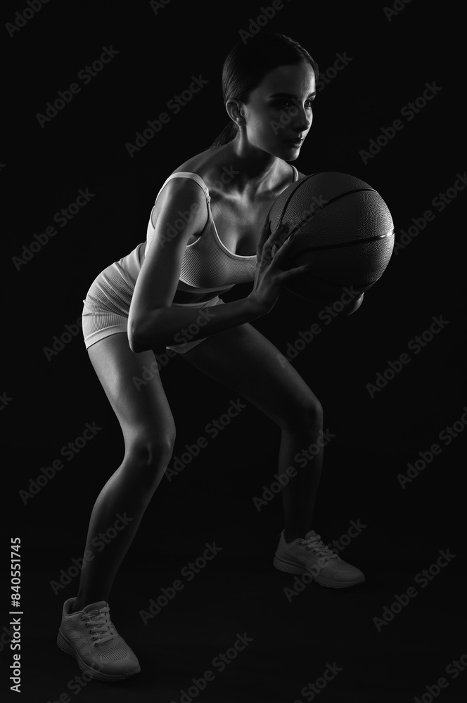 A beautiful slender girl athlete in shorts and in white top plays basketball. A beautiful slender girl athlete in shorts and in white top plays basketball.