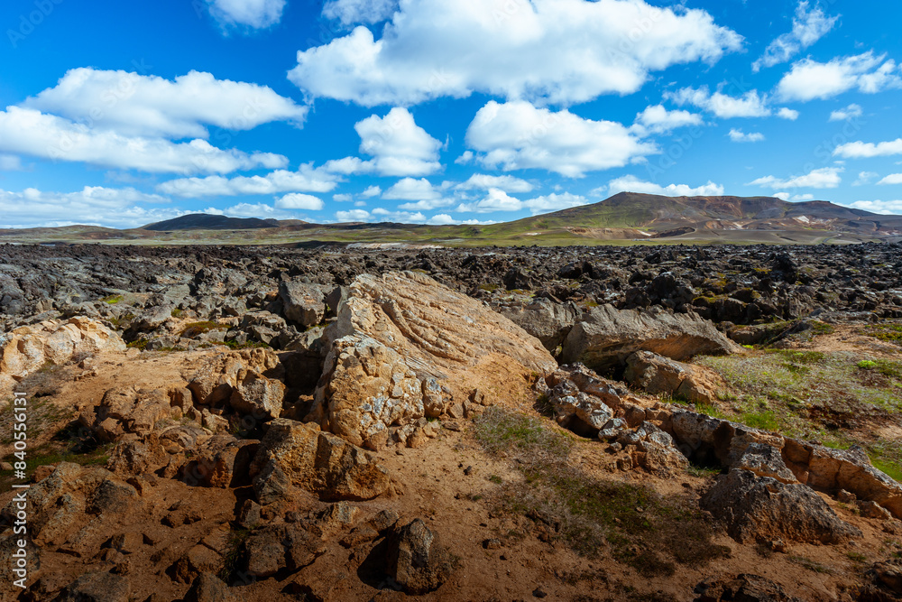 Obraz premium Amazing lava field in the highlands of Iceland near Myvatn, black old lava flows and volcanic rocks, mountains in the background
