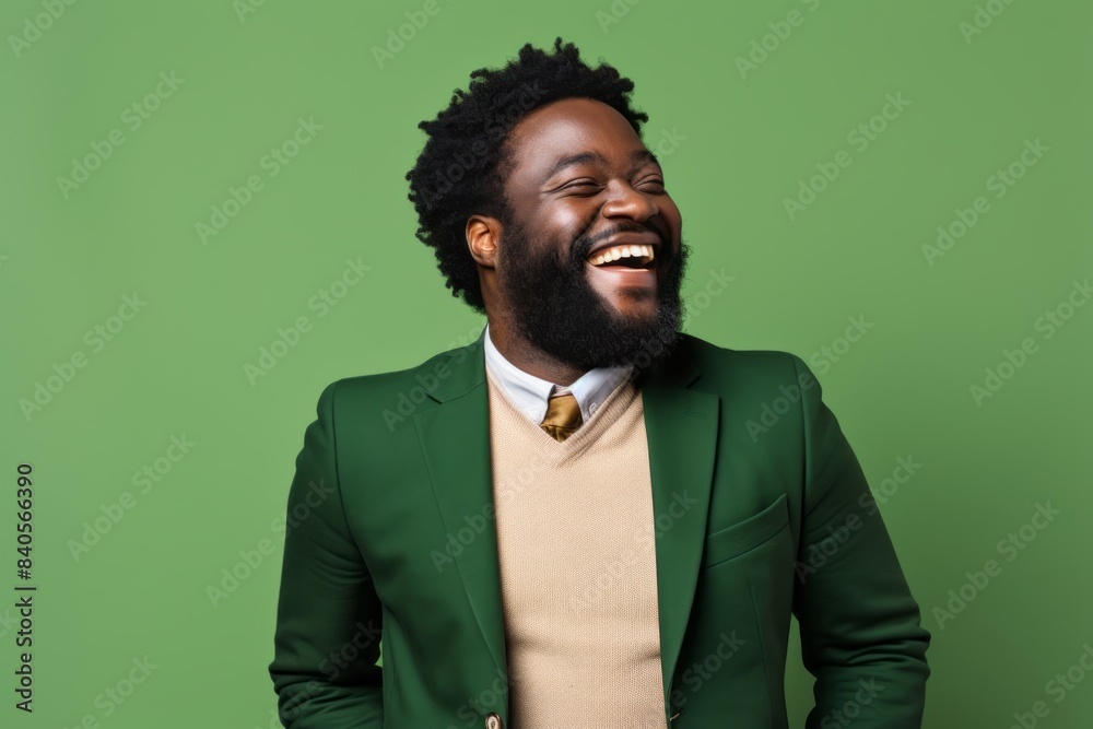 Portrait of a grinning afro-american man in his 30s dressed in a stylish blazer on soft green background Portrait of a grinning afro-american man in his 30s dressed in a stylish blazer on soft green background