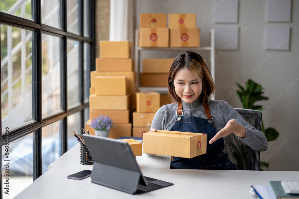 A woman is sitting at a desk with a box in front of her A woman is sitting at a desk with a box in front of her