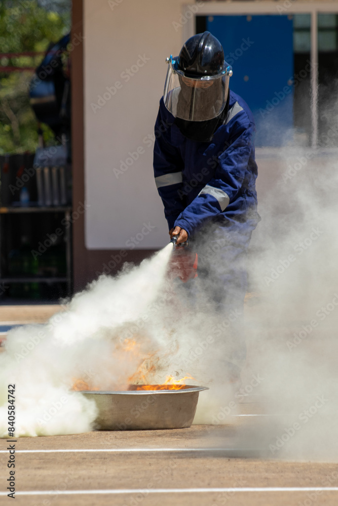 Fototapeta premium Firefighter using a fire extinguisher Stop the incident filled with white smoke