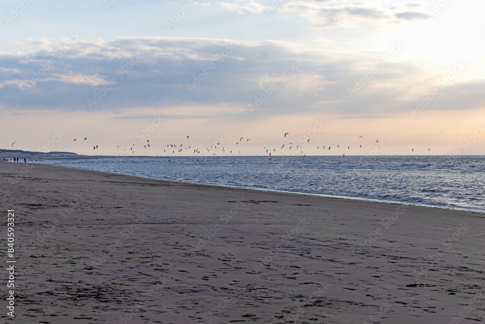 Picture of many kitesurfers on the beach of Ouddorp in Holland in the evening light Picture of many kitesurfers on the beach of Ouddorp in Holland in the evening light