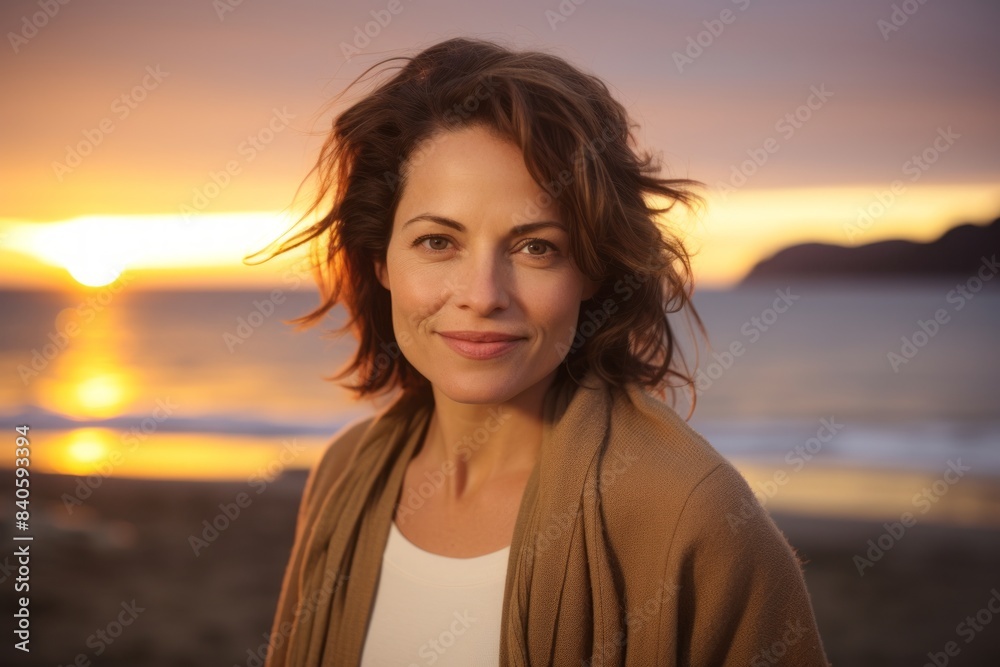 Portrait of a glad woman in her 40s wearing a chic cardigan over stunning sunset beach background Portrait of a glad woman in her 40s wearing a chic cardigan over stunning sunset beach background