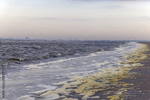 Panoramic picture over the beach of Ouddorp in Holland with the silhouette of the port of Rotterdam on the horizon