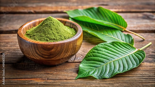 Mitragyna speciosa (kratom) leaves and medicinal powder in a wooden cup, against a textured wood background , kratom, leaves, medicinal, powder, wooden cup, wood texture photo