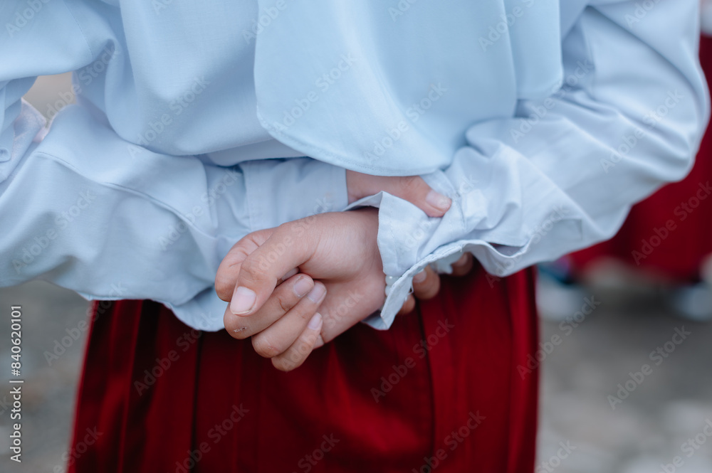 elementary school child holding his hands behind his body while resting in place during the ceremony elementary school child holding his hands behind his body while resting in place during the ceremony