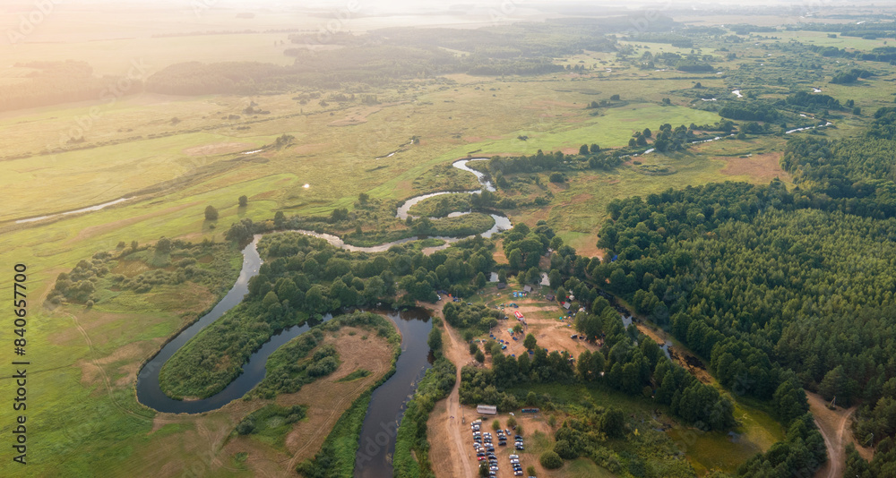 Panorama view from above of the summer landscape. Orange sunset sky, fields and forests, rivers and roads Panorama view from above of the summer landscape. Orange sunset sky, fields and forests, rivers and roads