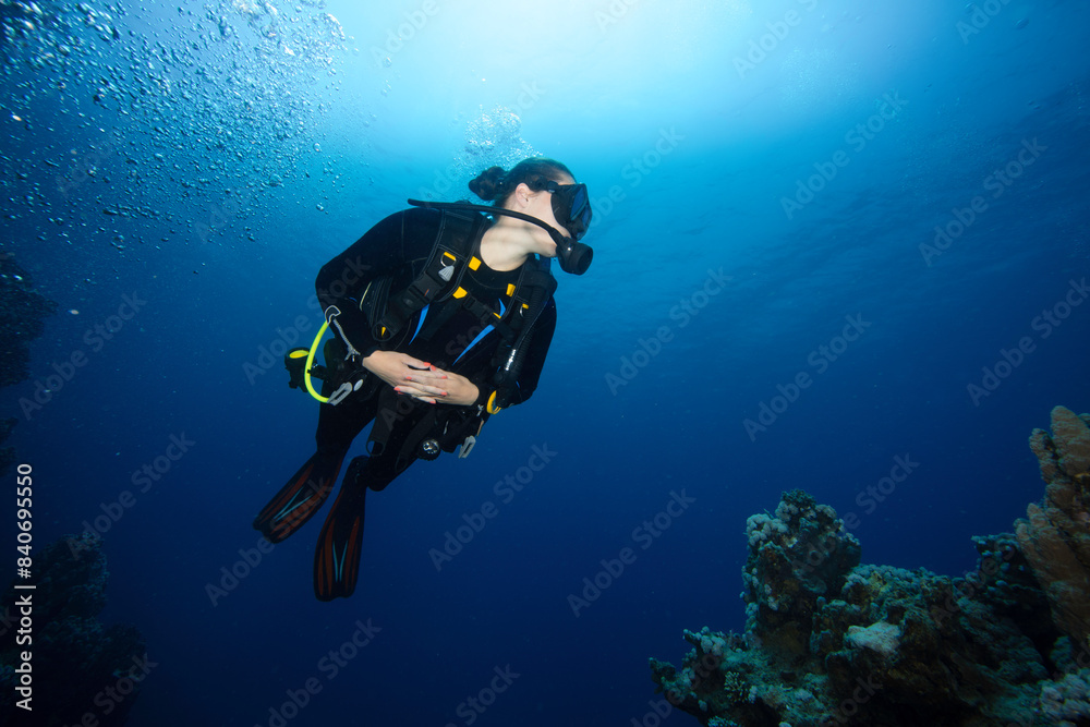 Girl Scuba Diver Diving on Tropical Coral Reef with Blue Background and Reef Fish. Girl Scuba Diver Diving on Tropical Coral Reef with Blue Background and Reef Fish.