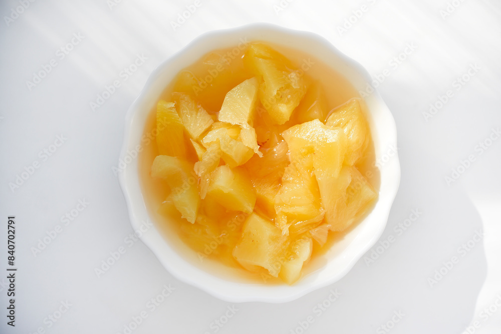 Canned pineapples in a white cup. Chopped pineapples. Canned pineapples in a white cup. Chopped pineapples.