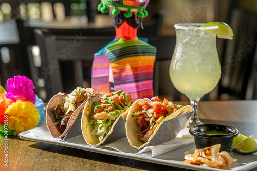 A Trio of Tasty Tacos - Suadero (braised brisket on blue corn tortilla), Grouper and Shrimp tacos with house-made salsa verde, grilled onion and lime, with a margarita.