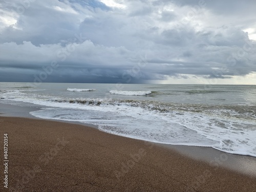 Dramatic weather, view, low dark blue clouds, waves on the sea, coastline, all awaiting of rain or storm
