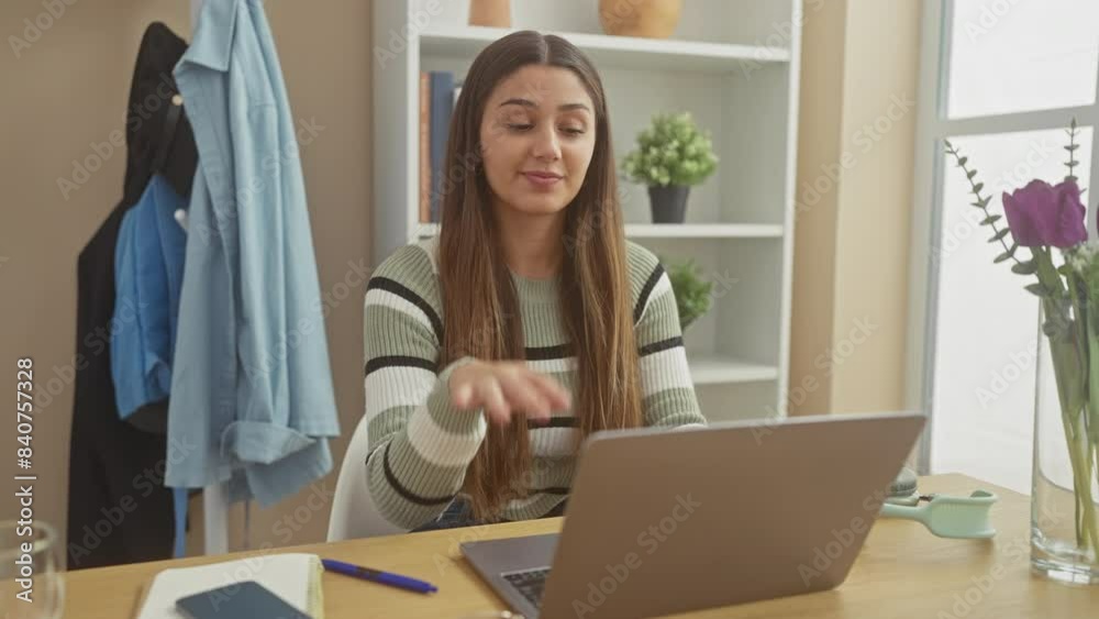 A relaxed young hispanic woman works on her laptop in a tidy living room, exuding comfort and focus. A relaxed young hispanic woman works on her laptop in a tidy living room, exuding comfort and focus.
