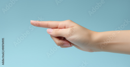 hand with an extended index finger pointing to the left set against a light blue background for concepts related to guidance, direction, instruction, warning