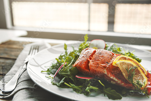 Plate, fish and lemon in restaurant, food and choice for health, wellness and nutrition with fine dining. Salmon, dinner and closeup with leaves, vegetables and seafood for diet with pescatarian meal photo