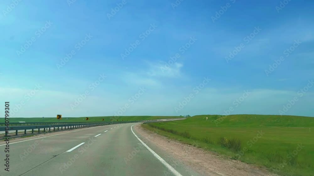 Summer road trip. Windshield view of driving on a straight highway in the countryside on a sunny day Summer road trip. Windshield view of driving on a straight highway in the countryside on a sunny day