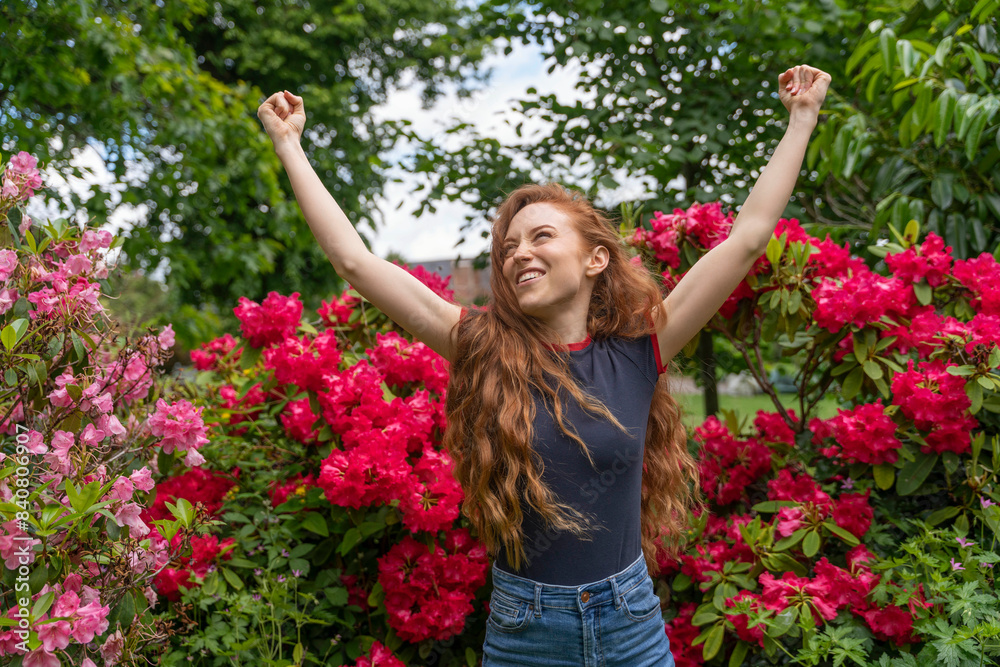 Woman Rejoicing Amidst Spring Blooms in a Lush Garden Woman Rejoicing Amidst Spring Blooms in a Lush Garden