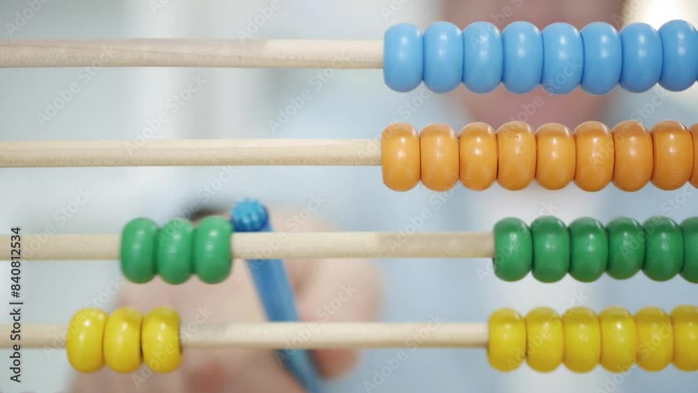 Blurred Shooting with a Man Using a Balls Calculator. A Counter with Colored Balls, a Tool Used by Kids for Learning to Calculate. Blurred Shooting with a Man Using a Balls Calculator. A Counter with Colored Balls, a Tool Used by Kids for Learning to Calculate.