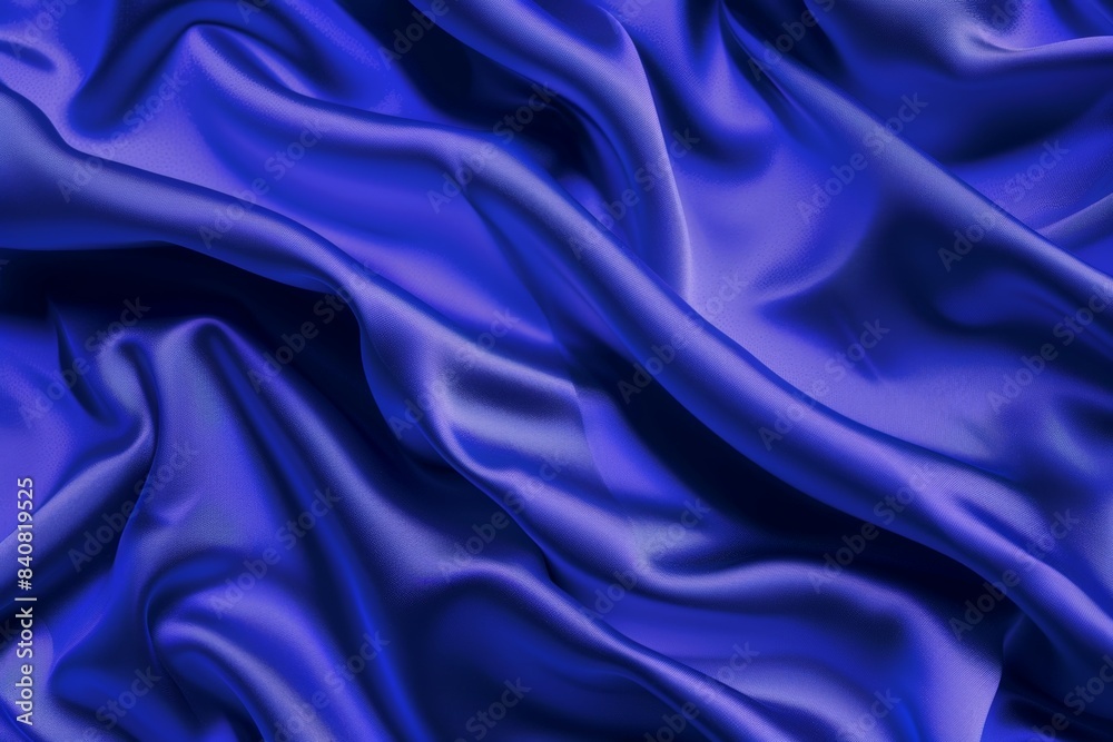 Fototapeta premium Luxurious blue satin fabric is flowing and forming soft folds, creating a beautiful and elegant background. This high-quality material is perfect for adding a touch of sophistication to any design