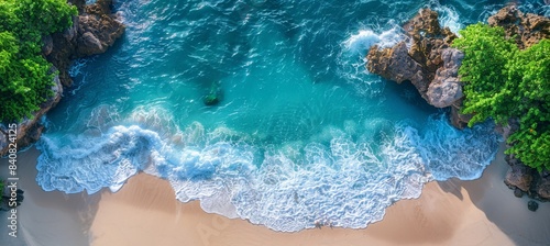 Aerial top view of a white sand beach and turquoise sea water with waves in a tropical island for a summer vacation background