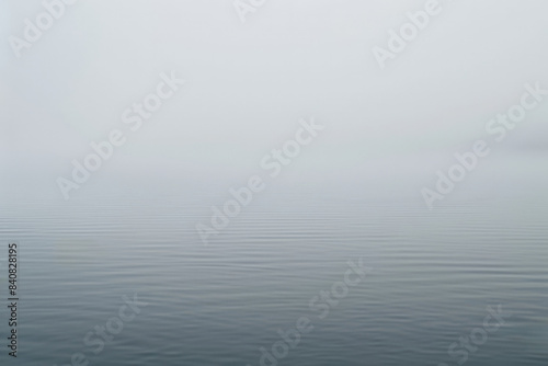 Minimalist seascape showing a tranquil water surface merging with a foggy sky, creating a serene and peaceful atmosphere © Enigma