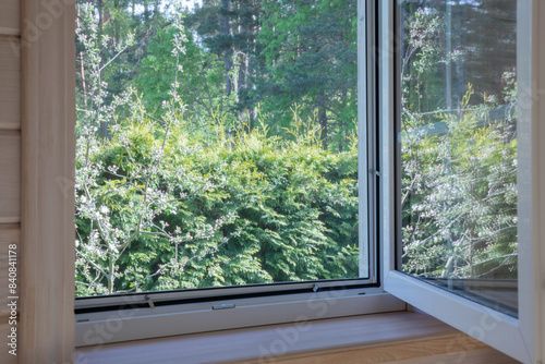 White window with mosquito net in scandinavian wooden house.