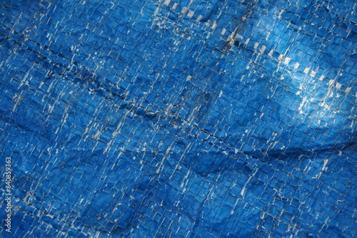 Weathered and damaged tent surface backdrop, grungy and rustic blue backdrop for presentation, cracked pattern texture background