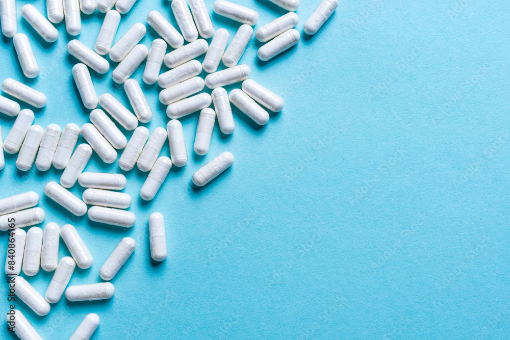 White medical capsules on blue background. White medical capsules on blue background.