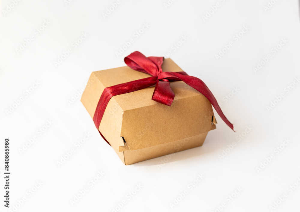 Obraz premium cardboard packaging, bento cake on white background, red bow