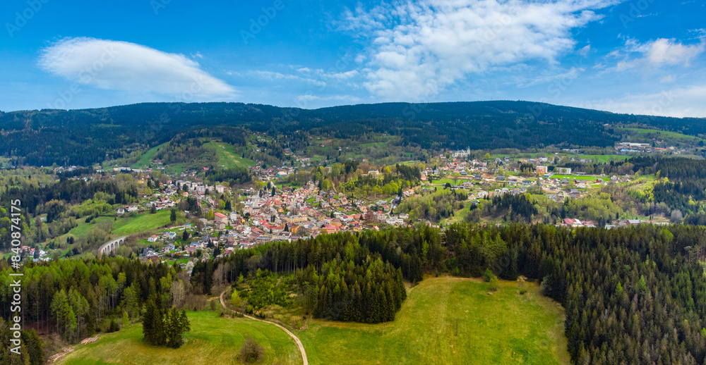 A vibrant springtime panorama over Smrzovka town, nestled amidst lush green hills and forests under a partly cloudy sky. Czechia A vibrant springtime panorama over Smrzovka town, nestled amidst lush green hills and forests under a partly cloudy sky. Czechia